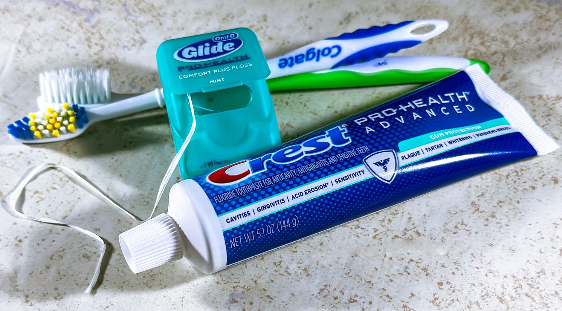 Close-up of dental care items including toothbrush, floss, and toothpaste for oral hygiene. — A thick yoga mat Rather Than A