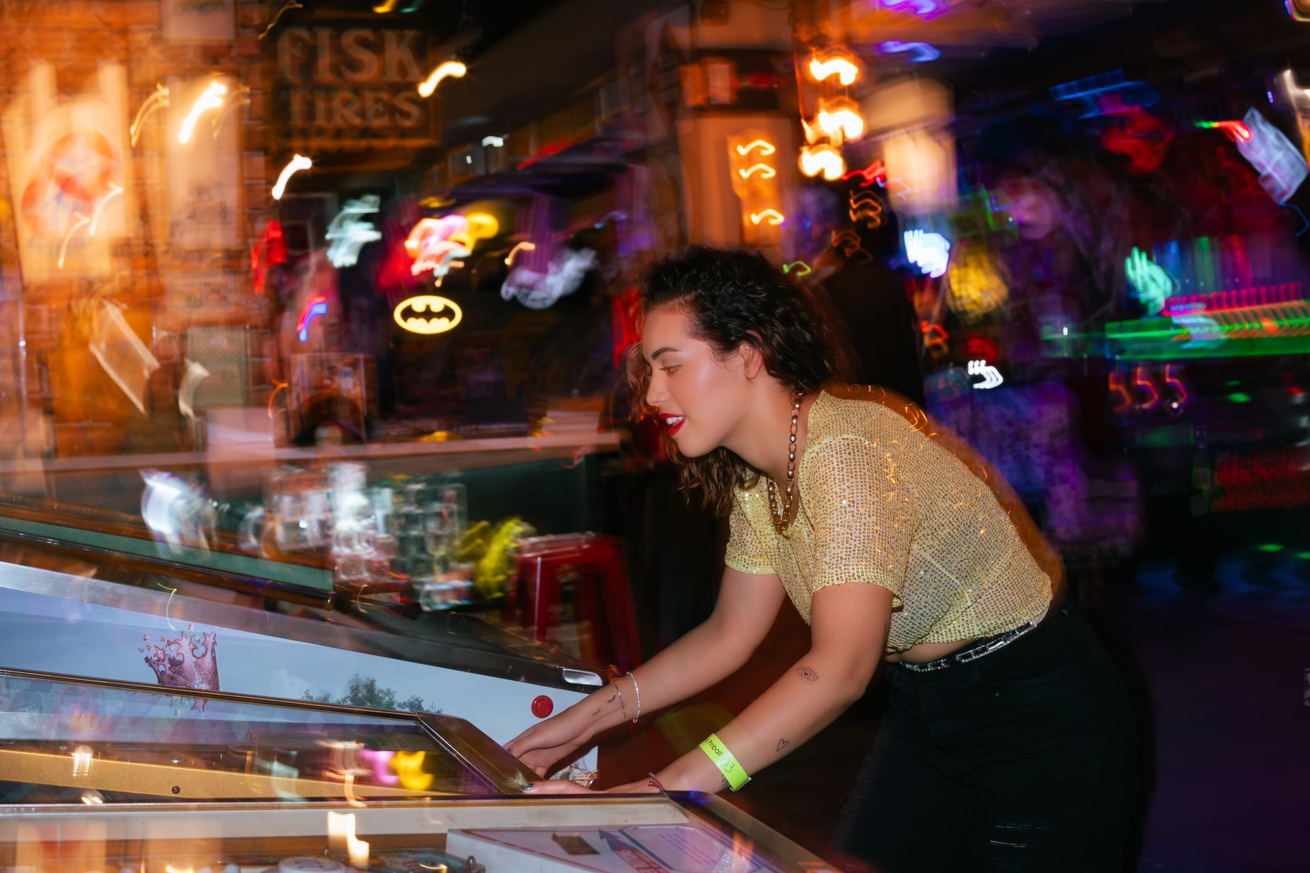 Young woman enjoying a night out playing pinball in an energetic arcade setting. — British Sports Betting Platform Built for