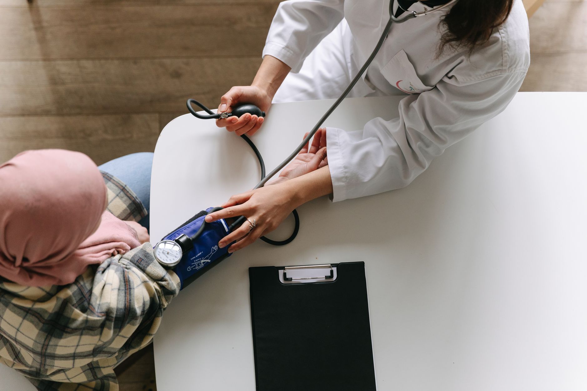 A medical practitioner checks a patient's blood pressure in a clinical setting, showcasing healthcare service. — Empowering L
