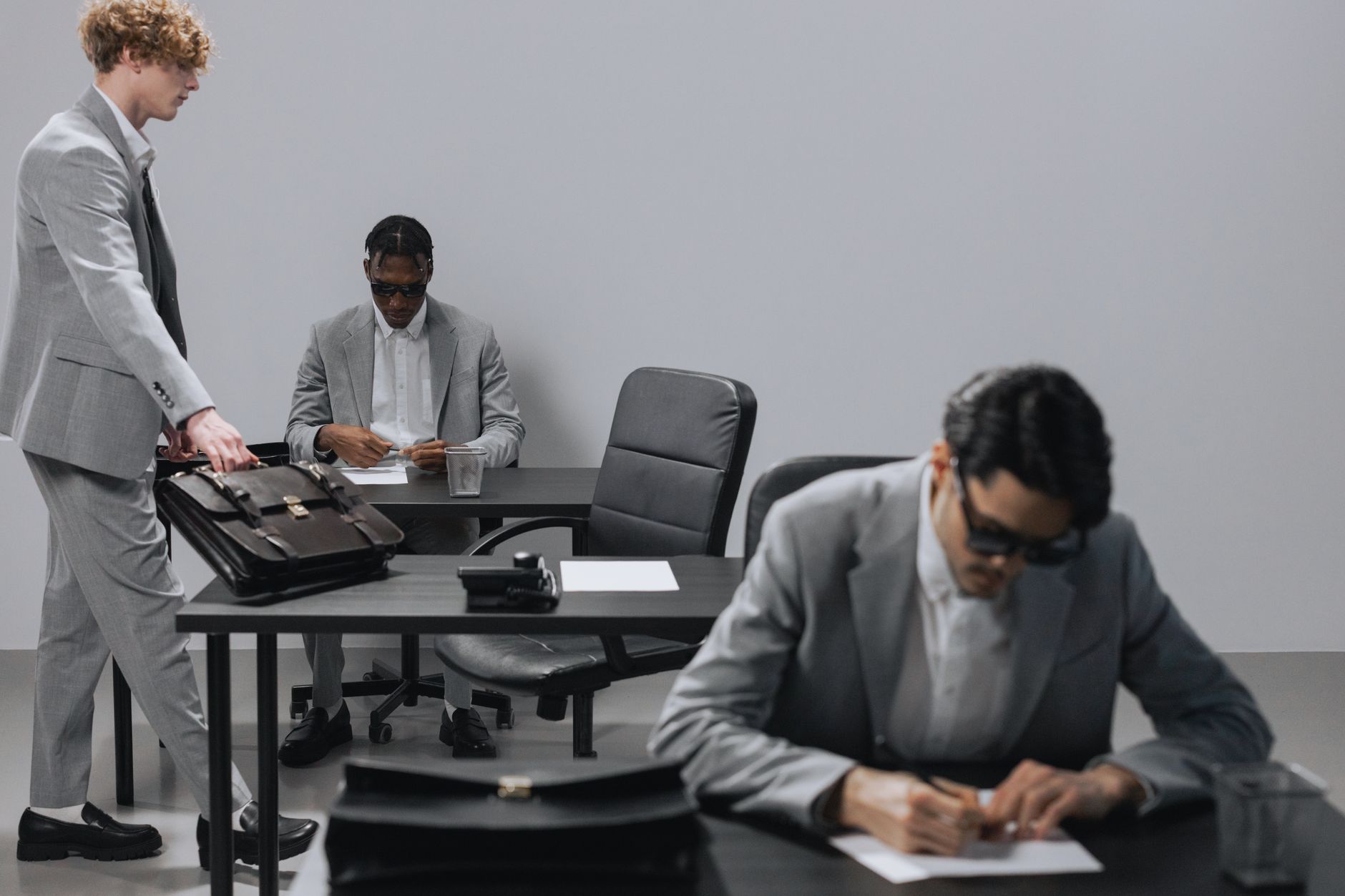 Business office with diverse employees in gray suits working at desks in an indoor setting. — Find TOR Websites with One-Clic