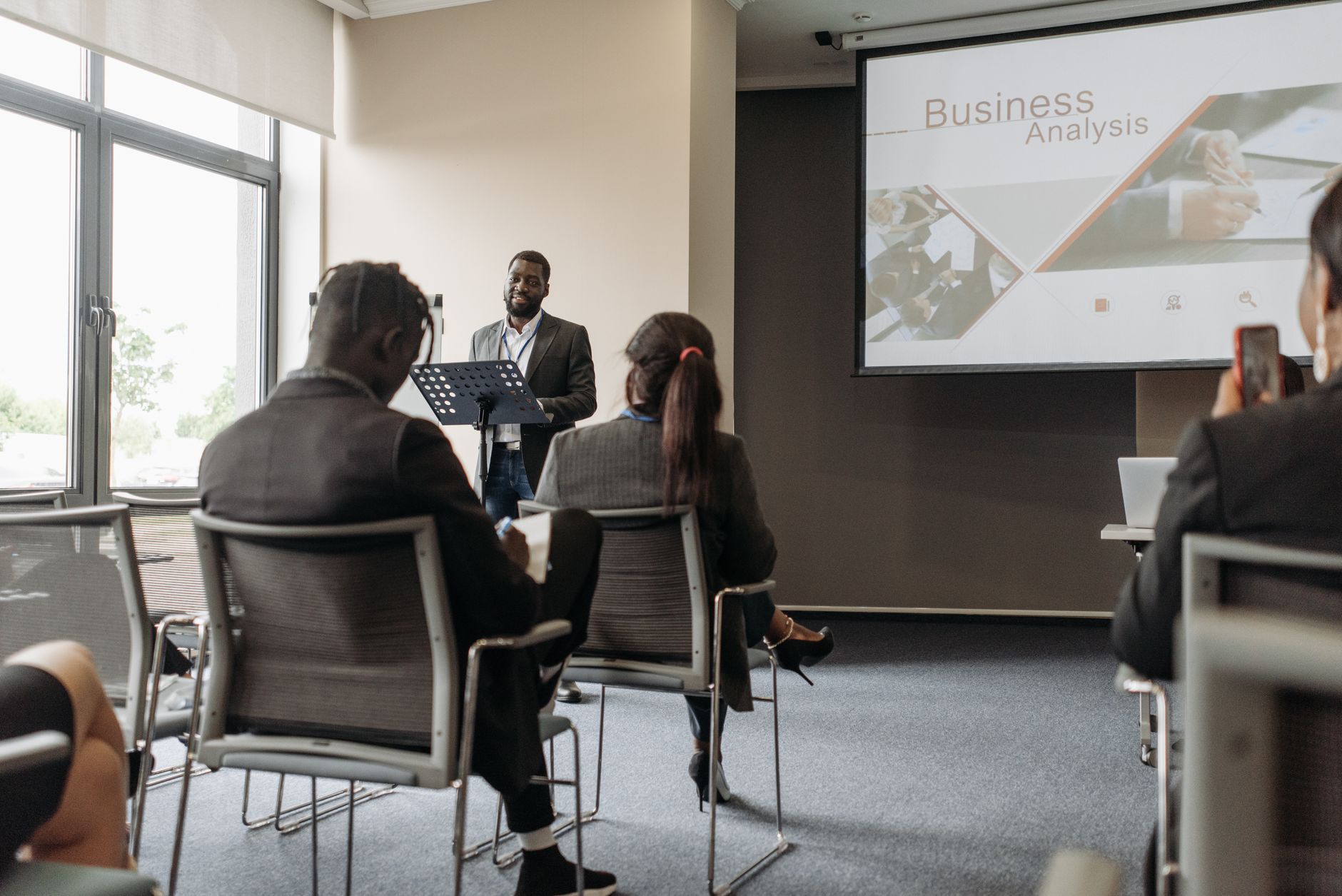 A business professional delivering a presentation in a conference room with diverse attendees. — Five Advantages of Futures t