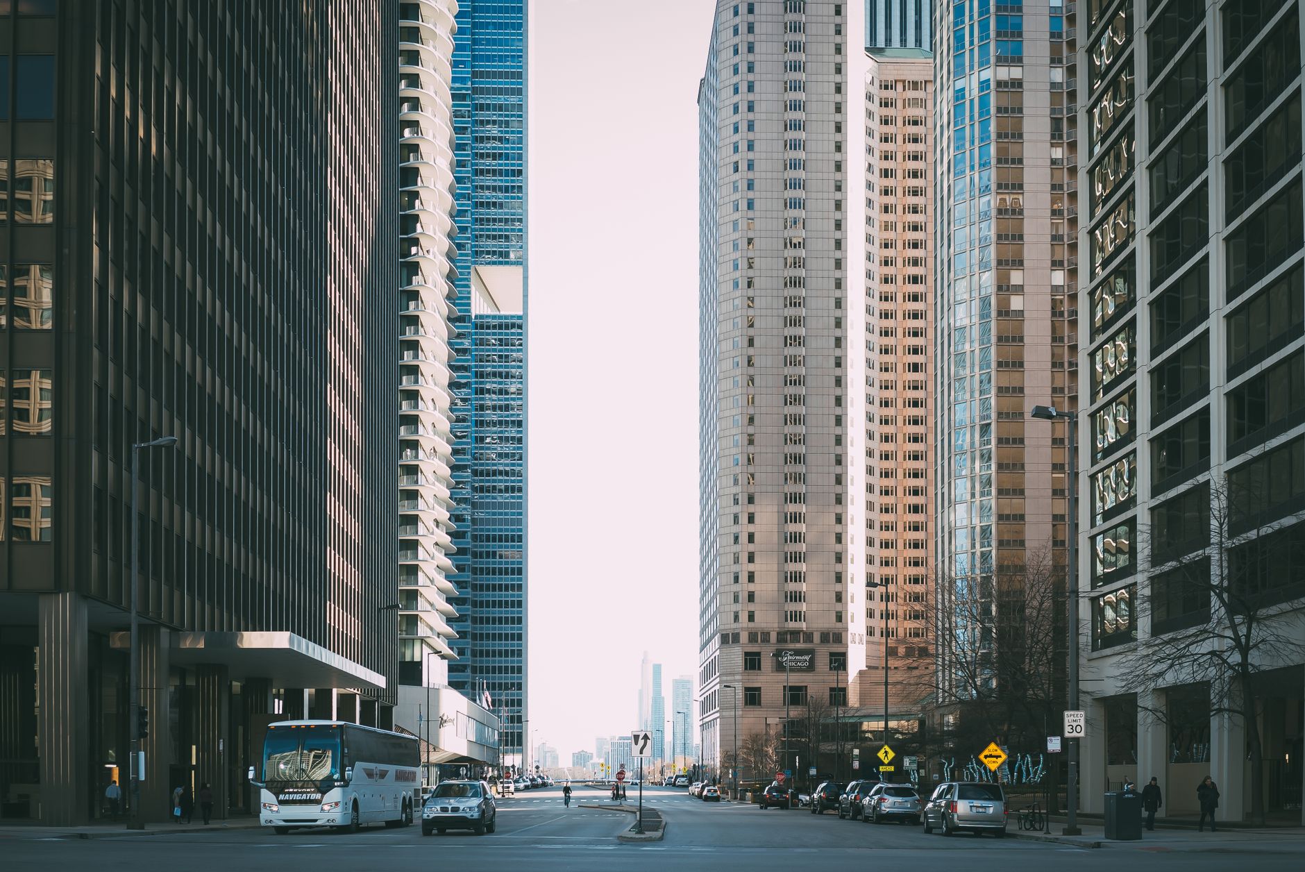 Vibrant city street scene with tall skyscrapers and city life full of cars and pedestrians. — Foreclosure Costs: How to Pick