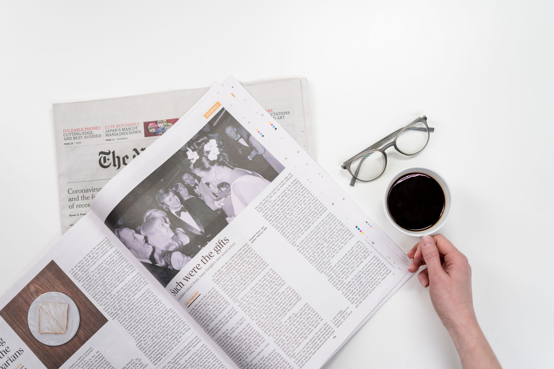 Overhead view of newspaper reading with coffee and glasses on a white table. — Guide to Selling Your Business Online: How to