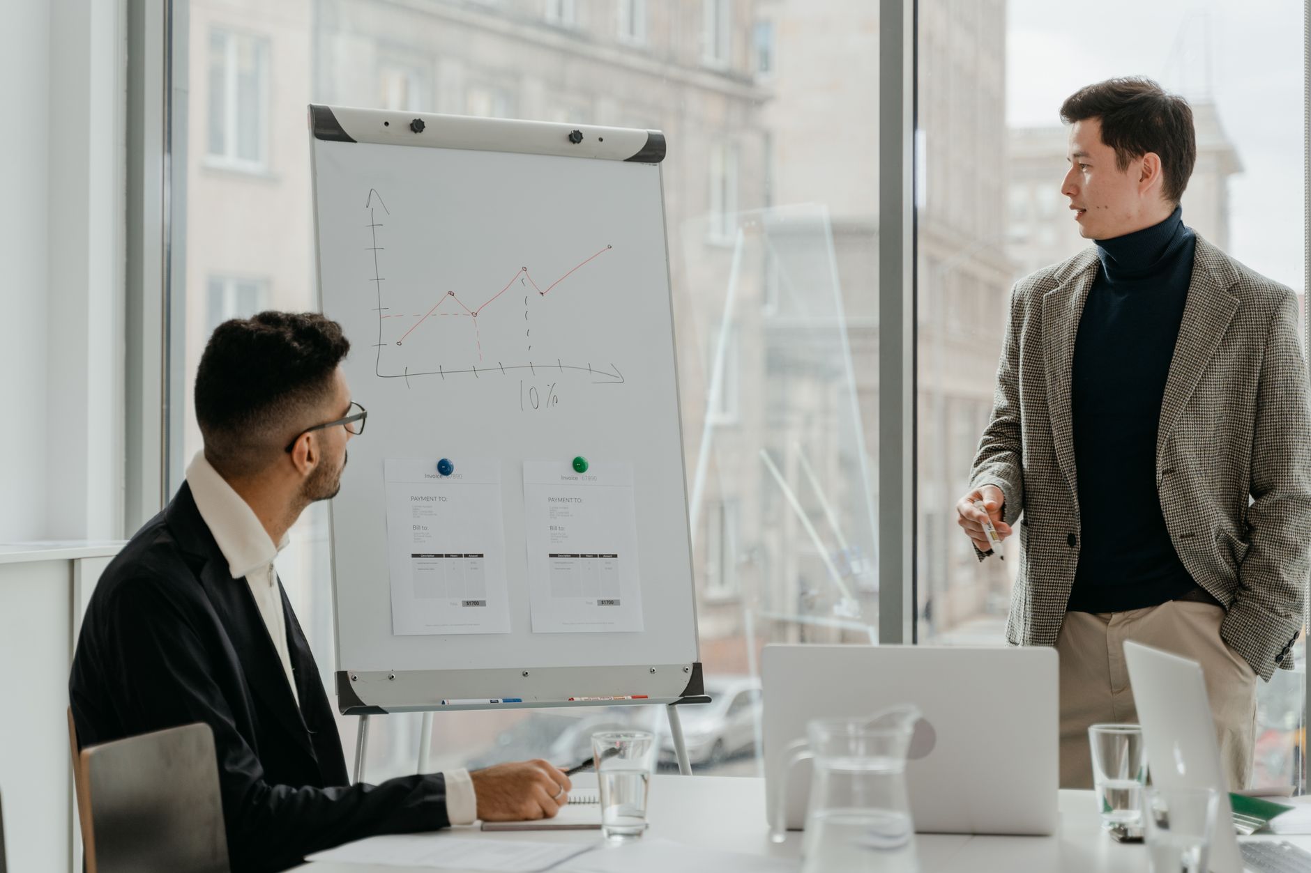 Professionals discussing a business chart in a modern office. — How to Effectively Advertise Your Goods and Services Using Fr