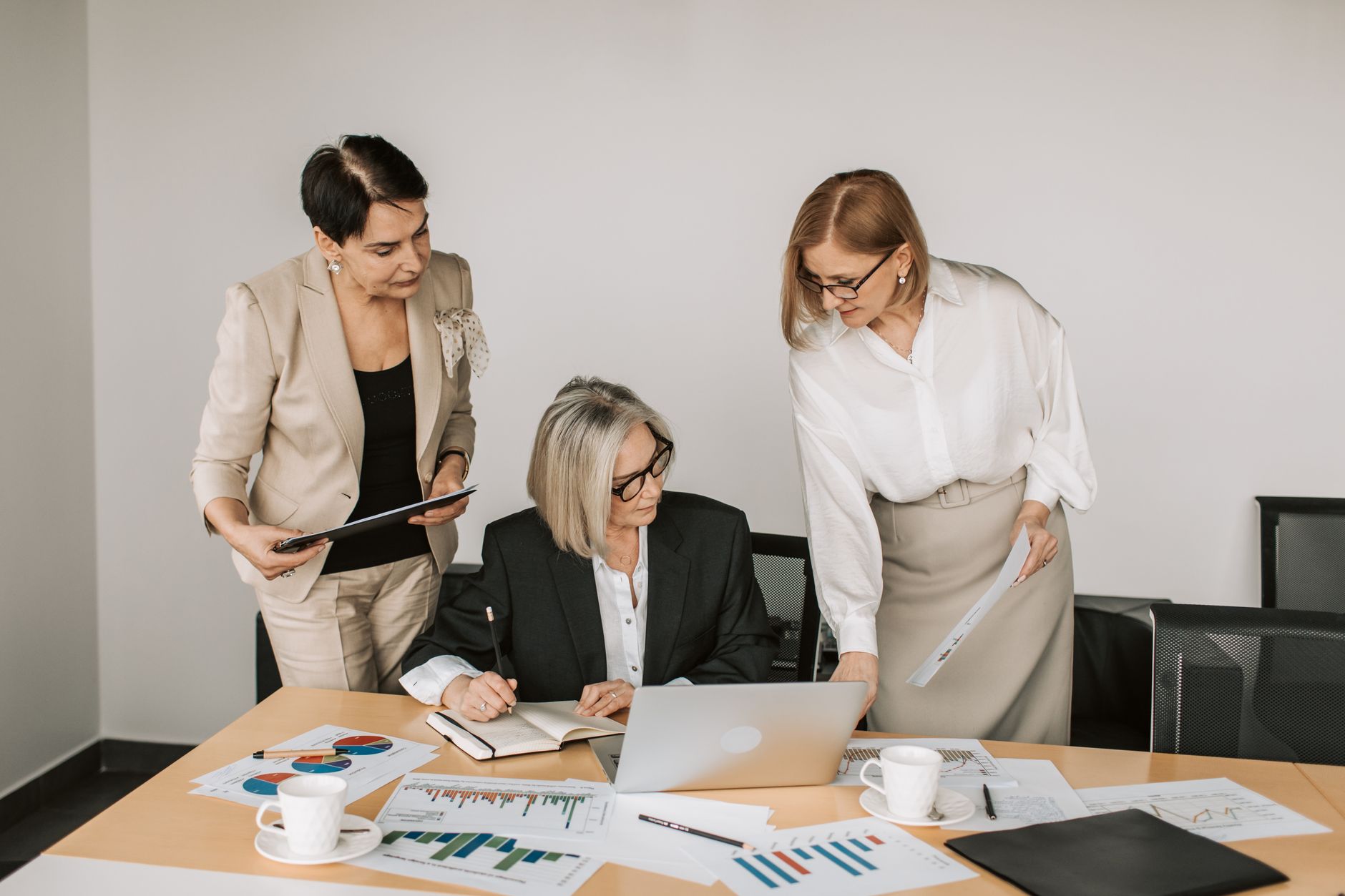 Three businesswomen discussing documents during a meeting in a modern office setting. — How To Make The Most Of Smart Light