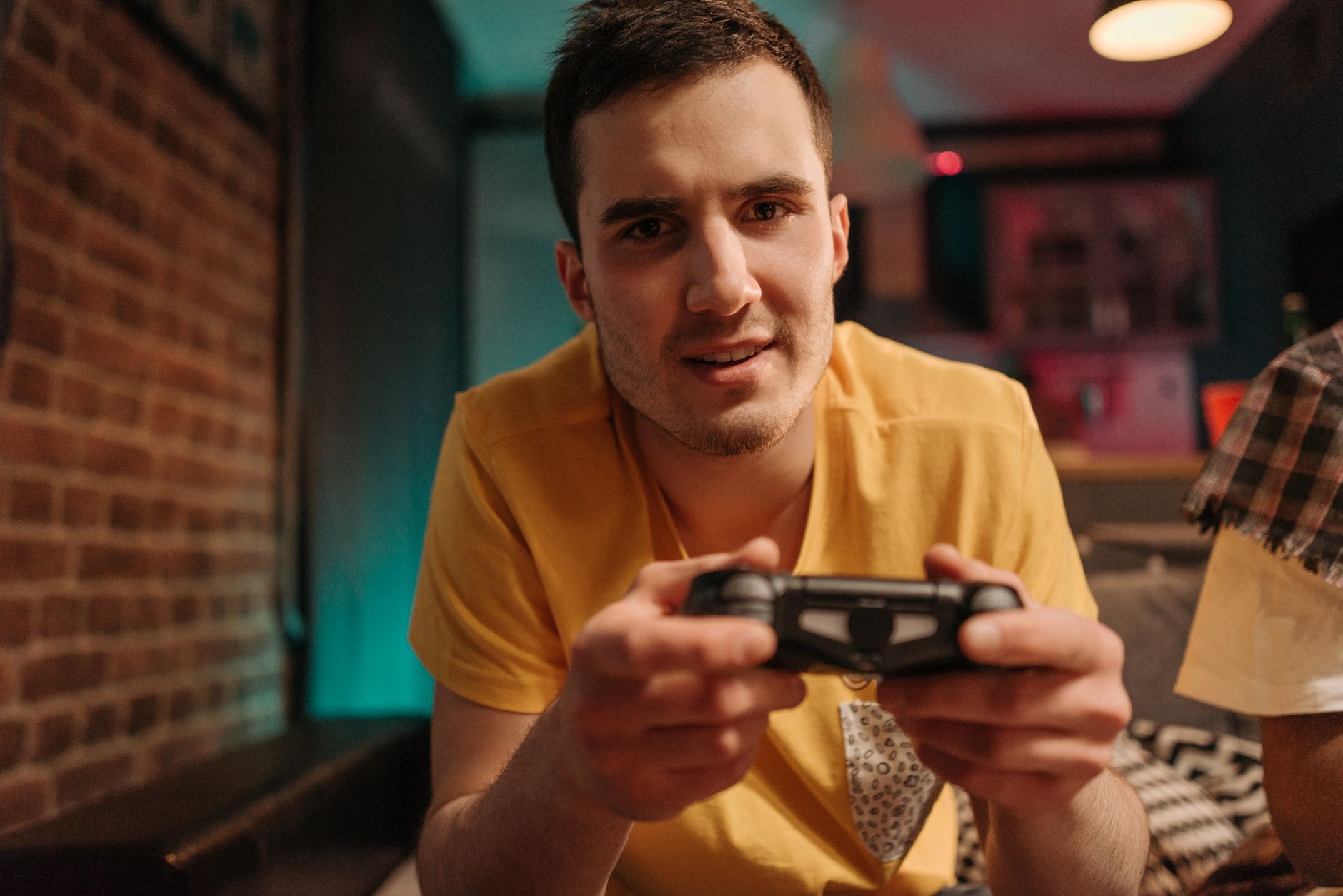 Focused young man enjoying video games with a controller indoors. — Play Blackjack At Bigwinner: The Best Casino Game