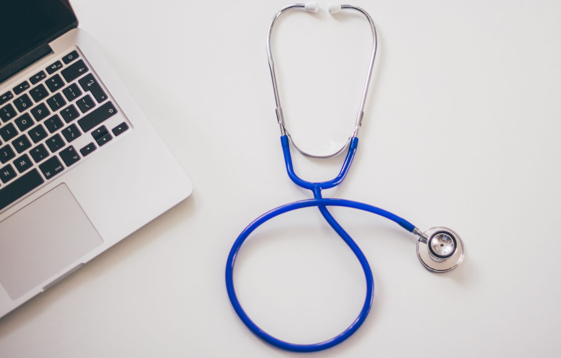 Medical stethoscope and laptop on a white desk, symbolizing digital health solutions. — Redefining You: A Guide to Abdominopl