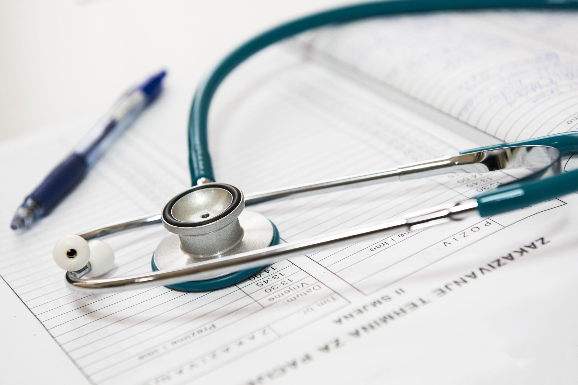 A stethoscope and pen resting on a medical report in a healthcare setting. — Relaxation on the Go Massage Tricks for the Busy