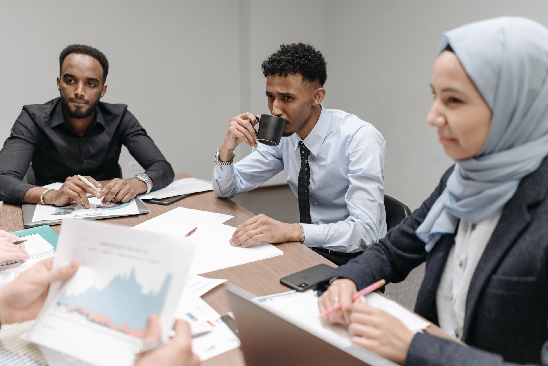 A multicultural team engaged in discussion during an office meeting, highlighting diversity and teamwork. — Role of Accessibi