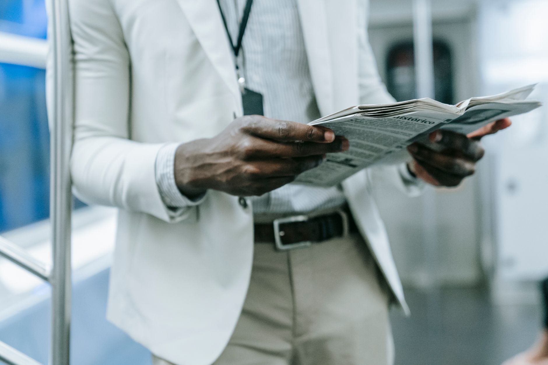 A professional in a blazer reads a newspaper while commuting on a train. — Enjoy Free Access to your Credit Reports o