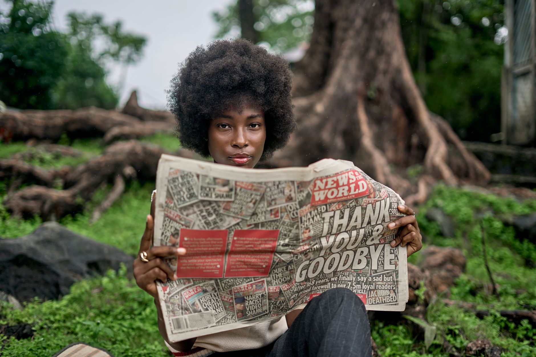 A woman enjoys reading a newspaper in a natural outdoor setting, showcasing leisure and nature. — Stylish Leather Wes