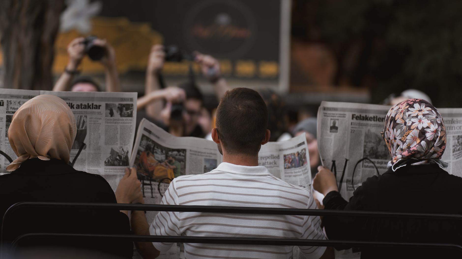 A candid moment of people reading newspapers on a bench in Ankara park. — Unlocking Maximum Productivity with a Dedic