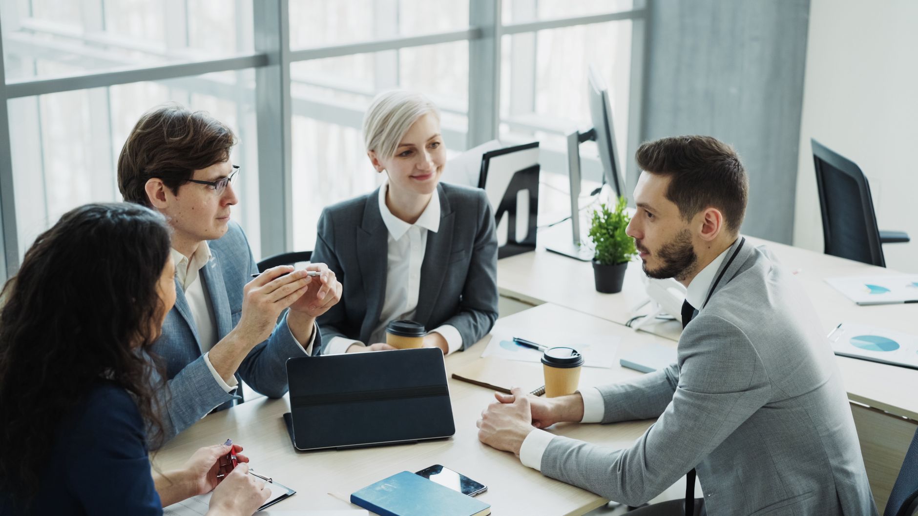 Group of professionals having a discussion in a modern office setting with natural light. — The Many Benefits Of Using A Mobi