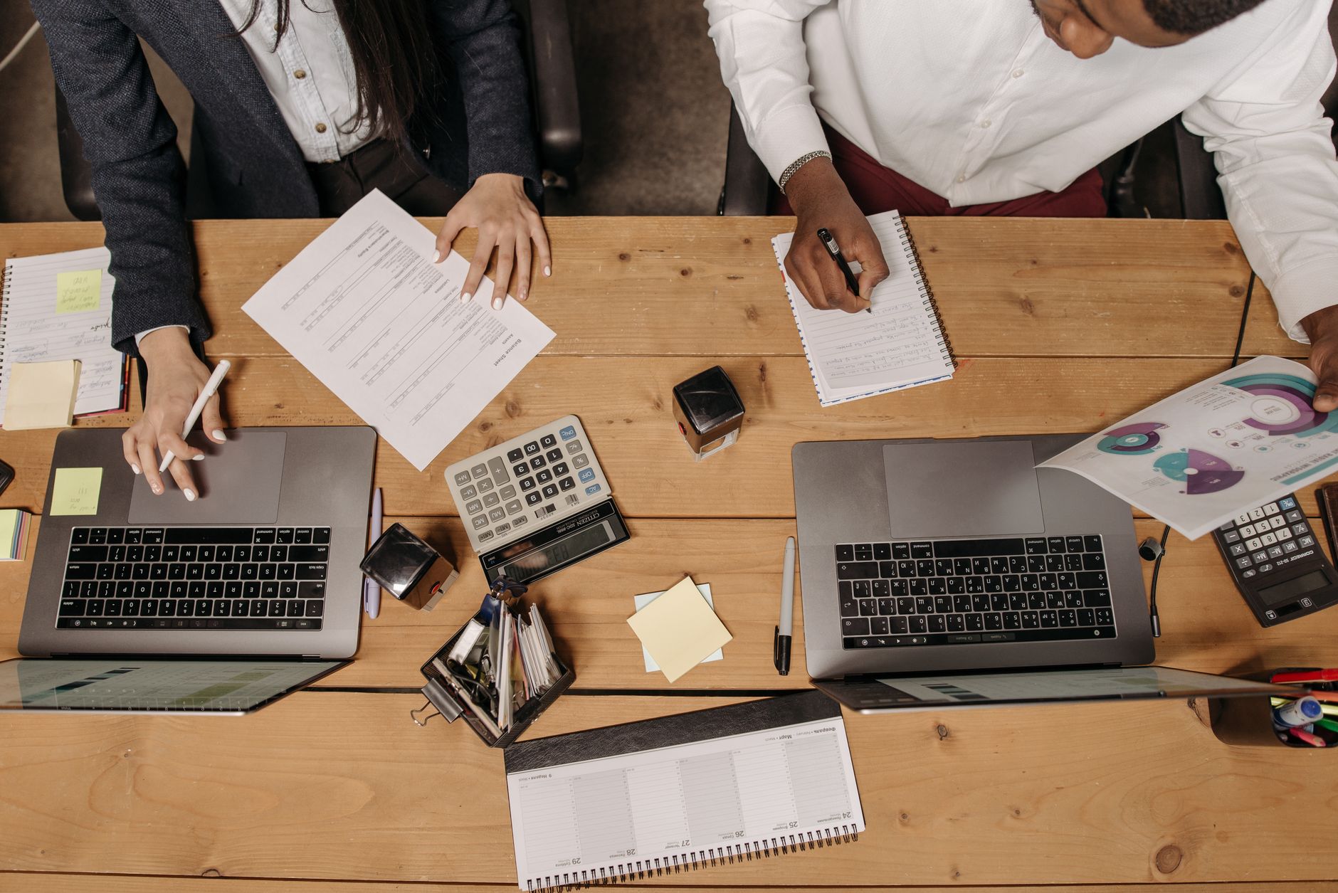 High-angle view of professionals working collaboratively with laptops and documents in an office. — Thick Yoga Mat: The Ultim