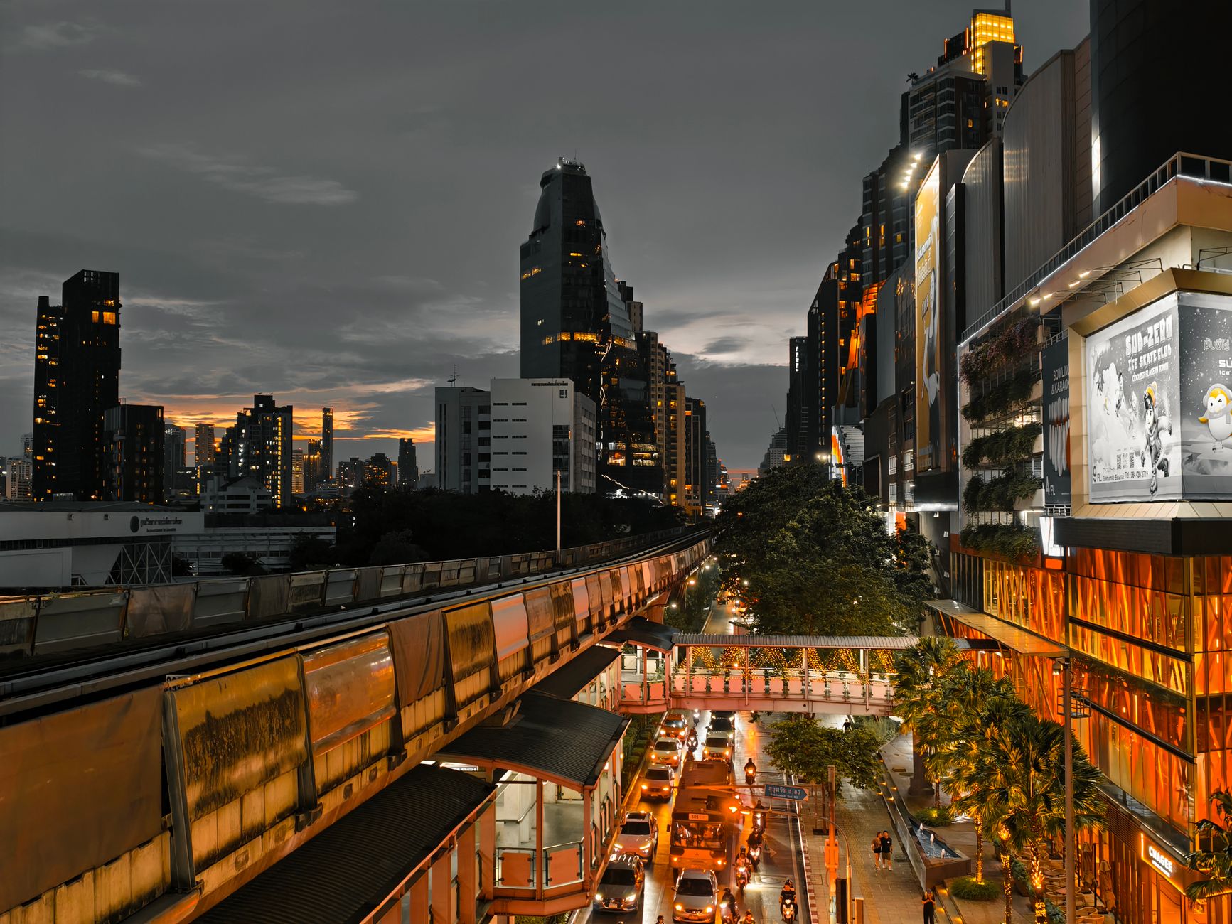 Cityscape at twilight showing busy traffic, skyscrapers, and an elevated train line in an urban setting. — Things You Should