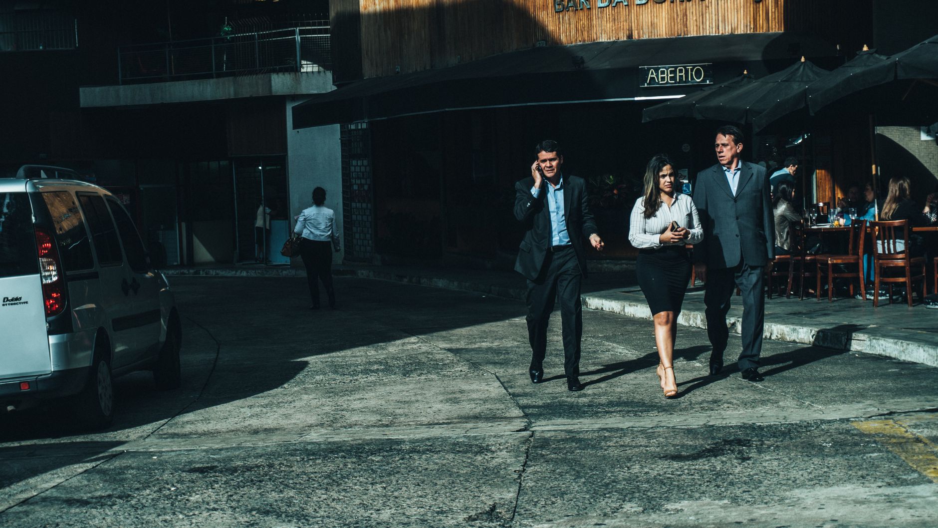 Three business professionals walk along a city street outside a cafe. — Unlocking Business Potential: Nihar Gala Strategic Bl