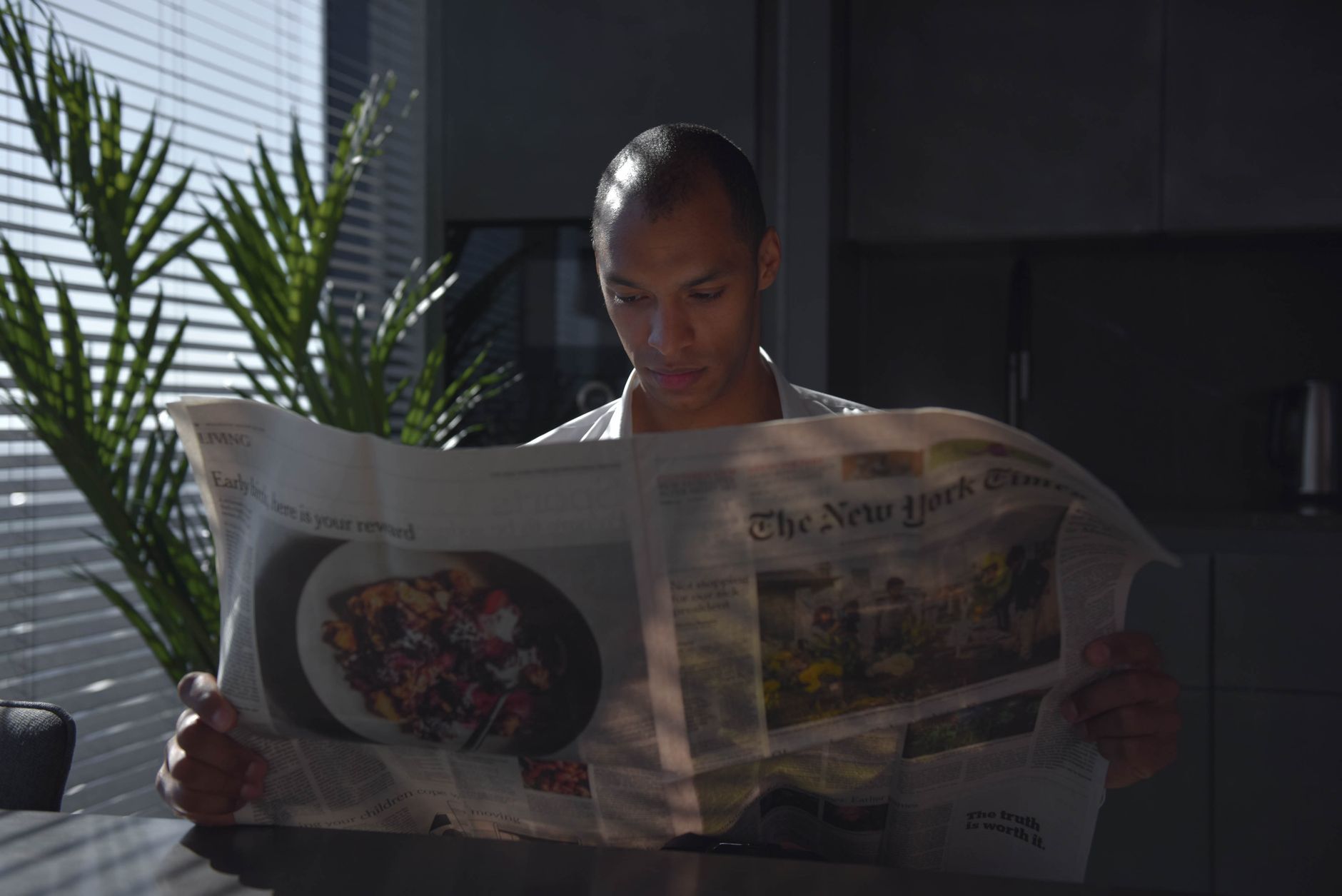 Businessman focused on reading newspaper in a sunny indoor office setting. — Use This Secret And You'll Win Even More At Onli